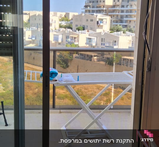 מרפסת עם מתלה כביסה ונוף לבניינים